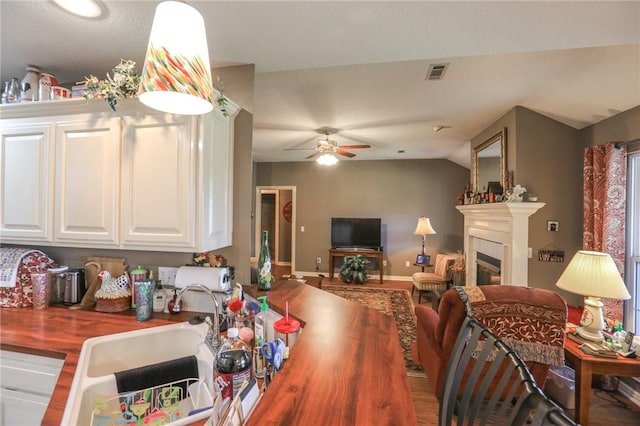 925 Lowell Ave, Cave Springs, AR 72718 - dining room featuring ceiling fan, a glass covered fireplace, lofted ceiling, and baseboards