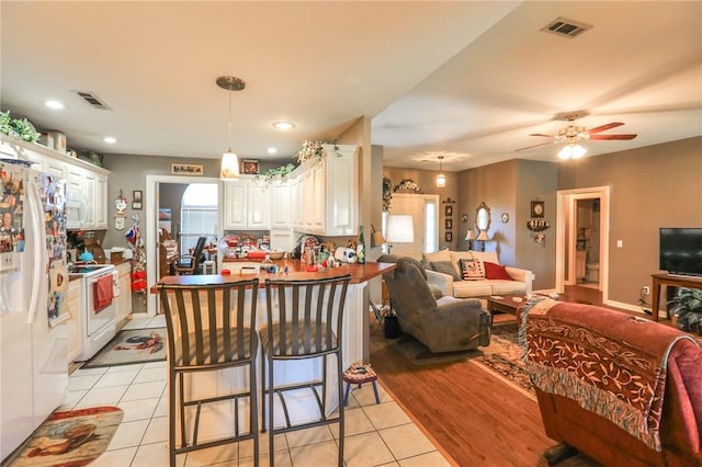 925 Lowell Ave, Cave Springs, AR 72718 - kitchen with white appliances, open floor plan, a peninsula, white cabinetry, and light tile patterned floors