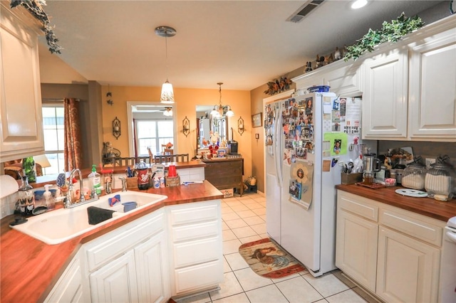 925 Lowell Ave, Cave Springs, AR 72718 - kitchen with butcher block countertops, a sink, white fridge with ice dispenser, a peninsula, and light tile patterned flooring