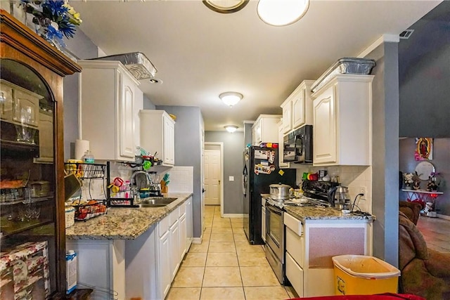 814 Colley St, Lowell, AR 72745 - kitchen with stainless steel stove, black microwave, a sink, backsplash, and light tile patterned floors