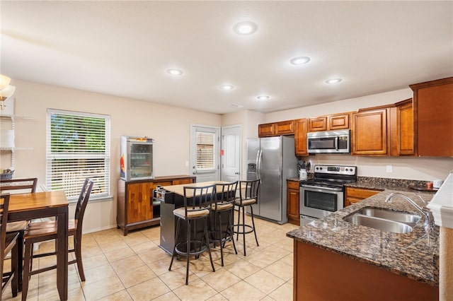 1503 W Kelley Dr, Rogers, AR 72756 - kitchen with appliances with stainless steel finishes, a sink, brown cabinetry, recessed lighting, and light tile patterned floors