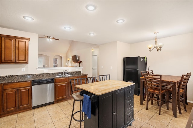 1503 W Kelley Dr, Rogers, AR 72756 - kitchen with stainless steel dishwasher, freestanding refrigerator, a sink, light tile patterned floors, and brown cabinetry