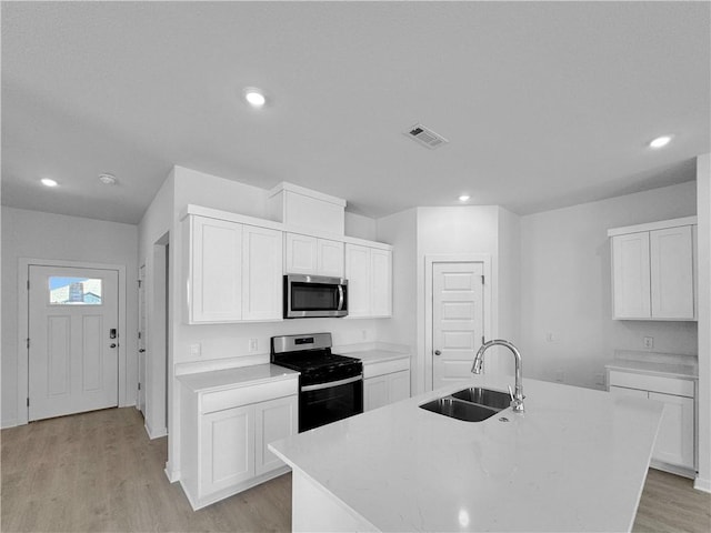 200 Greer St, Pea Ridge, AR 72751 - kitchen featuring appliances with stainless steel finishes, a sink, light countertops, light wood-style floors, and a center island with sink