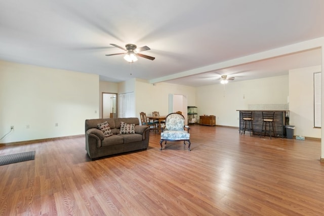 4 Torrido Ln, Bella Vista, AR 72715 - living area featuring ceiling fan, a bar, wood finished floors, and baseboards