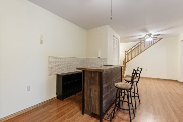 4 Torrido Ln, Bella Vista, AR 72715 - indoor dry bar featuring light wood-style flooring, stairway, ceiling fan, and baseboards