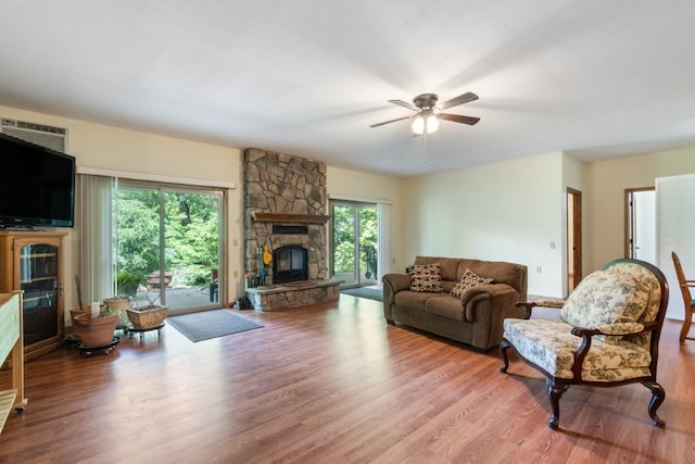 4 Torrido Ln, Bella Vista, AR 72715 - living room featuring a stone fireplace, wood finished floors, and a ceiling fan