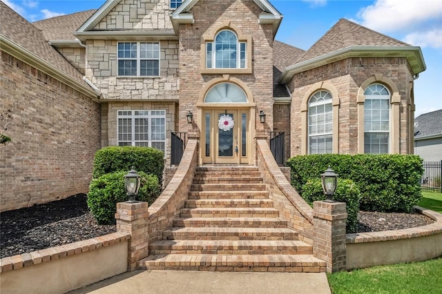 7 W Leiston Dr, Rogers, AR 72758 - view of exterior entry with roof with shingles and brick siding