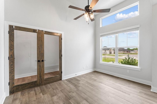 901 Carlock Dr, Pea Ridge, AR 72751 - unfurnished bedroom featuring wood finished floors, french doors, baseboards, a high ceiling, and ceiling fan