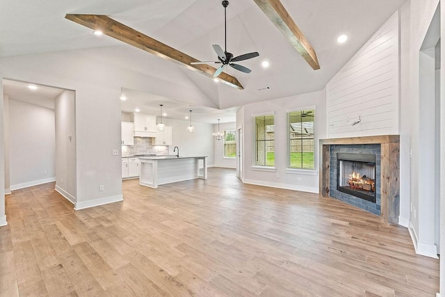 901 Carlock Dr, Pea Ridge, AR 72751 - unfurnished living room with ceiling fan, light wood-style flooring, baseboards, a lit fireplace, and a chandelier
