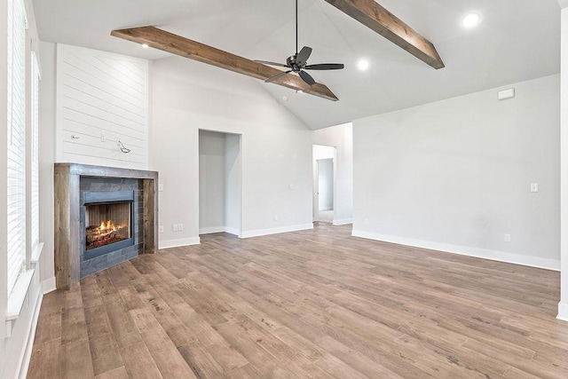 901 Carlock Dr, Pea Ridge, AR 72751 - unfurnished living room with beamed ceiling, a warm lit fireplace, a ceiling fan, wood finished floors, and recessed lighting