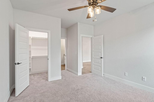 901 Carlock Dr, Pea Ridge, AR 72751 - unfurnished bedroom featuring a walk in closet, carpet, baseboards, a closet, and ceiling fan