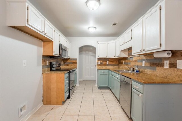 301 Halleck Coach Rd, Centerton, AR 72719 - kitchen with appliances with stainless steel finishes, a sink, backsplash, light tile patterned flooring, and white cabinets