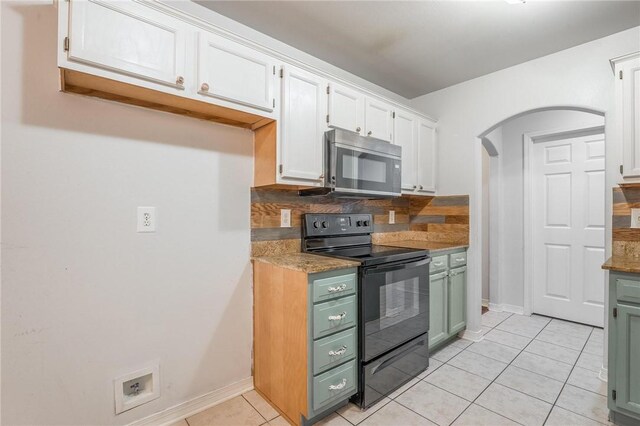 301 Halleck Coach Rd, Centerton, AR 72719 - kitchen with stainless steel microwave, black range with electric stovetop, arched walkways, light tile patterned flooring, and white cabinetry