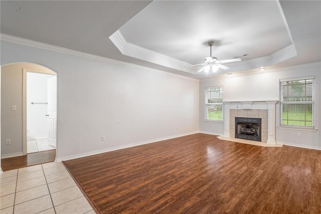301 Halleck Coach Rd, Centerton, AR 72719 - unfurnished living room with wood finished floors, a ceiling fan, a tray ceiling, arched walkways, and ornamental molding