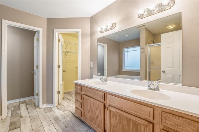301 Halleck Coach Rd, Centerton, AR 72719 - bathroom with a shower stall, a spacious closet, double vanity, wood finished floors, and a bathtub