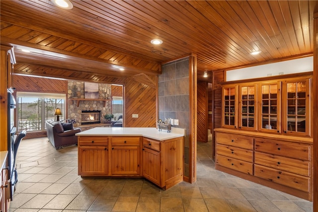 8093 Rockwood Ln, Rogers, AR 72756 - kitchen with a stone fireplace, wood ceiling, open floor plan, light countertops, and wooden walls