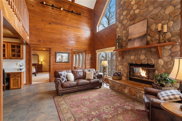 8093 Rockwood Ln, Rogers, AR 72756 - living room featuring a towering ceiling, plenty of natural light, wooden walls, and a fireplace