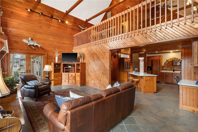 8093 Rockwood Ln, Rogers, AR 72756 - living room featuring wood walls, a towering ceiling, stone finish floors, and track lighting
