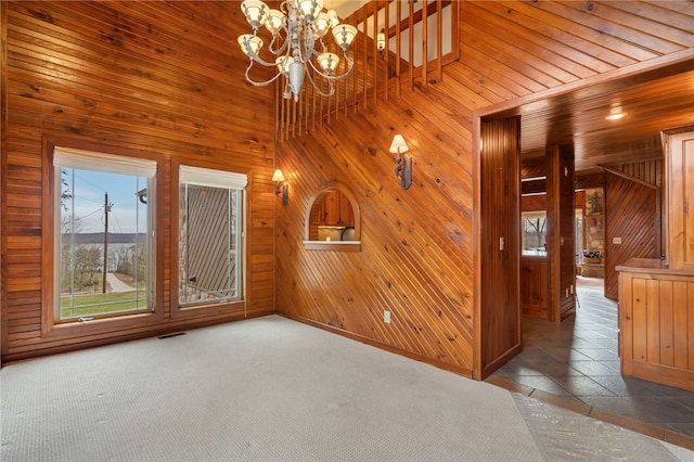 8093 Rockwood Ln, Rogers, AR 72756 - spare room with wood walls, a chandelier, baseboards, and stone tile flooring