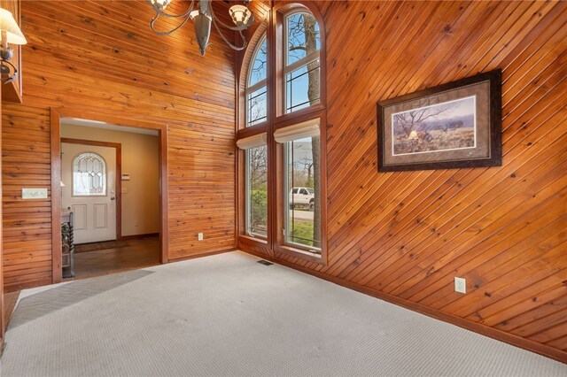 8093 Rockwood Ln, Rogers, AR 72756 - foyer with plenty of natural light, wooden walls, a chandelier, carpet floors, and a towering ceiling