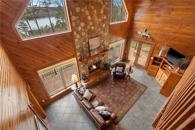 8093 Rockwood Ln, Rogers, AR 72756 - living area featuring wooden walls, a stone fireplace, a towering ceiling, and wooden ceiling