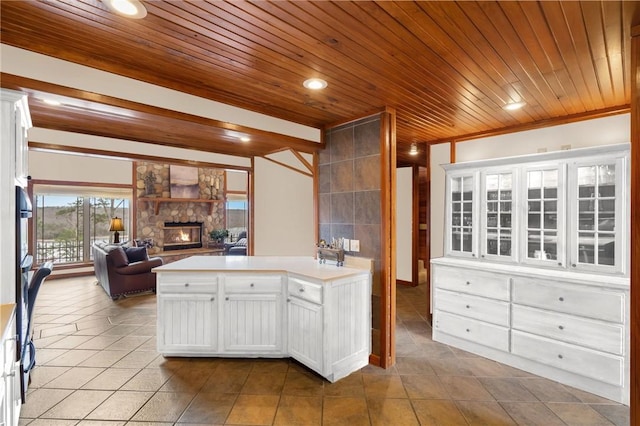 8093 Rockwood Ln, Rogers, AR 72756 - kitchen with wooden ceiling, open floor plan, a fireplace, light tile patterned floors, and white cabinets
