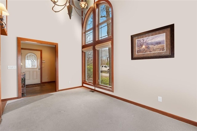 8093 Rockwood Ln, Rogers, AR 72756 - entrance foyer with carpet, a chandelier, baseboards, and a high ceiling