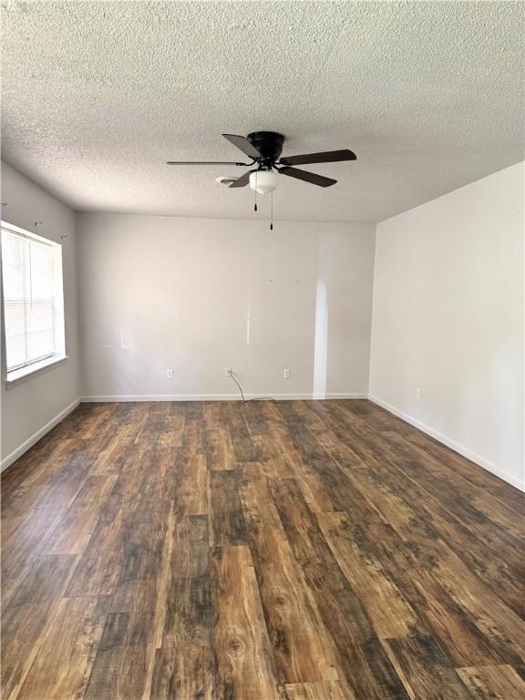 29 5th Ave, Dardanelle, AR 72834 - empty room featuring dark wood-type flooring, ceiling fan, a textured ceiling, and baseboards