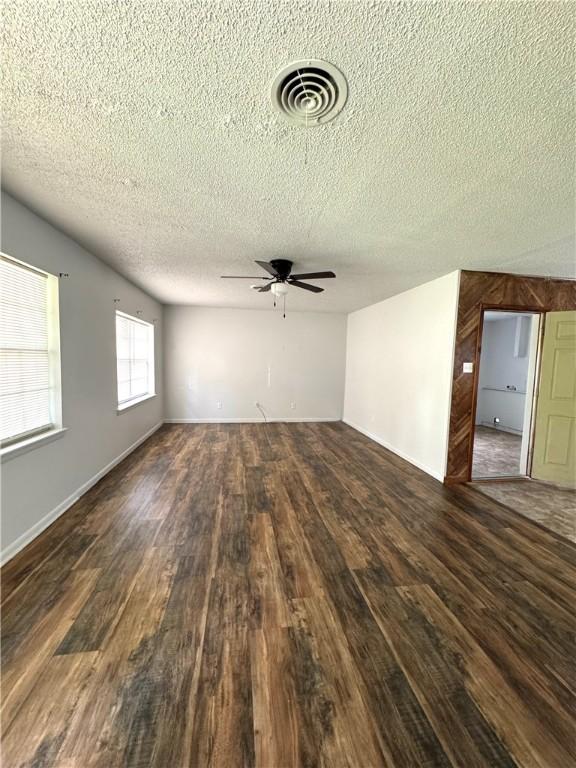 29 5th Ave, Dardanelle, AR 72834 - unfurnished living room with a textured ceiling, ceiling fan, and dark wood-style floors