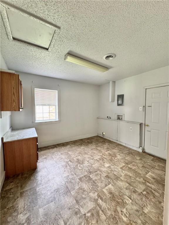 29 5th Ave, Dardanelle, AR 72834 - interior space featuring brown cabinets, a textured ceiling, and light countertops