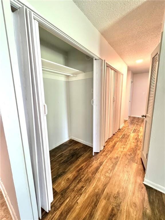 29 5th Ave, Dardanelle, AR 72834 - hallway featuring a textured ceiling, wood finished floors, and baseboards