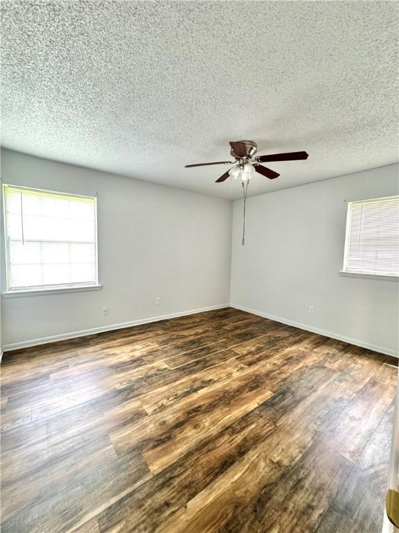 29 5th Ave, Dardanelle, AR 72834 - empty room with a ceiling fan, dark wood-type flooring, a textured ceiling, and baseboards