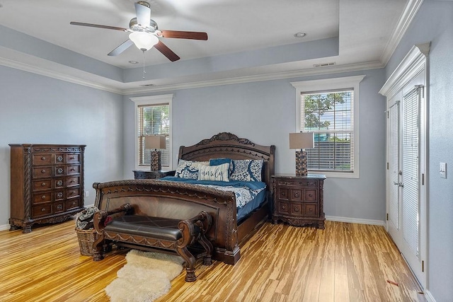 4206 NE Kenton Ave, Bentonville, AR 72712 - bedroom featuring a tray ceiling, wood finished floors, and multiple windows