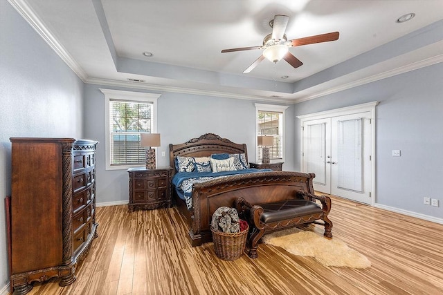 4206 NE Kenton Ave, Bentonville, AR 72712 - bedroom with a tray ceiling, baseboards, wood finished floors, ceiling fan, and crown molding