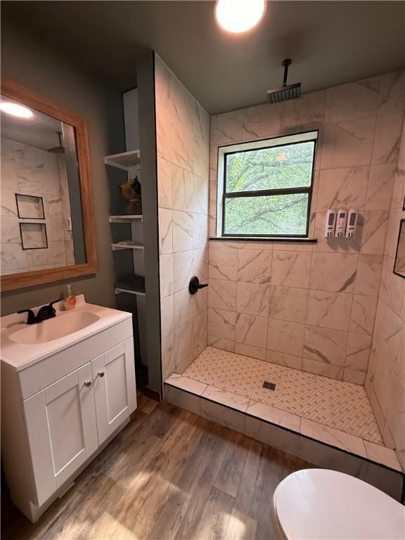2711 Skyline Dr, Russellville, AR 72802 - bathroom with vanity, wood finished floors, tiled shower, and toilet