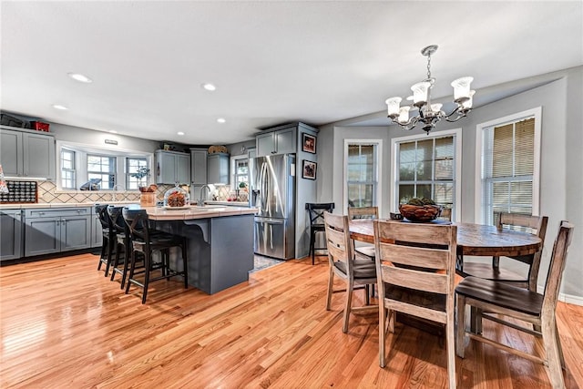 14620 Ravenwood Ln, Garfield, AR 72732 - kitchen with stainless steel fridge, an island with sink, a chandelier, light wood finished floors, and recessed lighting