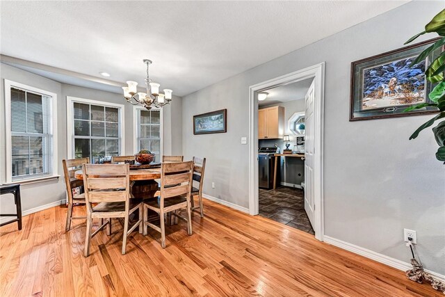 14620 Ravenwood Ln, Garfield, AR 72732 - dining area featuring a chandelier, light wood finished floors, and baseboards