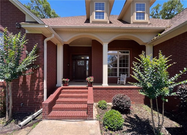 10059 Birdie St, Dardanelle, AR 72834 - view of exterior entry with brick siding, a porch, and roof with shingles