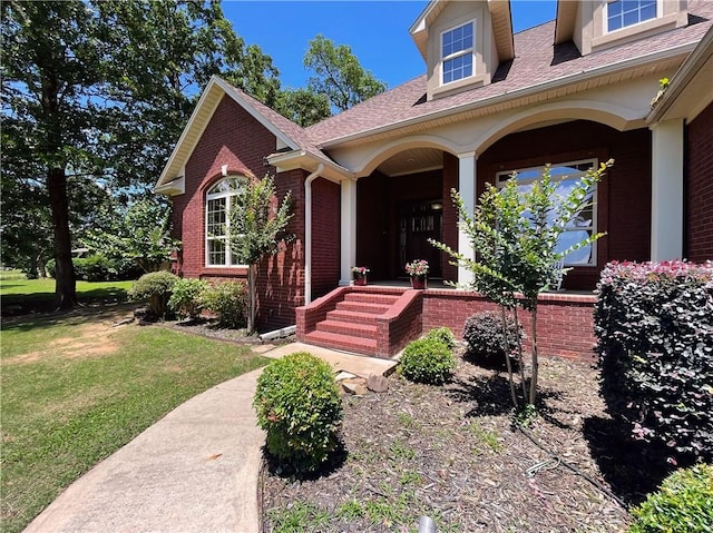 10059 Birdie St, Dardanelle, AR 72834 - property entrance featuring brick siding, a lawn, covered porch, and a shingled roof