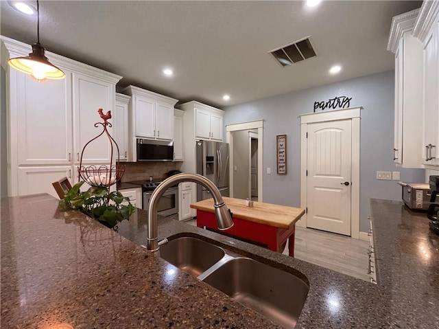 10059 Birdie St, Dardanelle, AR 72834 - kitchen featuring stainless steel appliances, white cabinetry, recessed lighting, a sink, and dark stone countertops