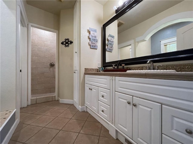 10059 Birdie St, Dardanelle, AR 72834 - bathroom featuring tile patterned flooring, double vanity, a tile shower, and baseboards