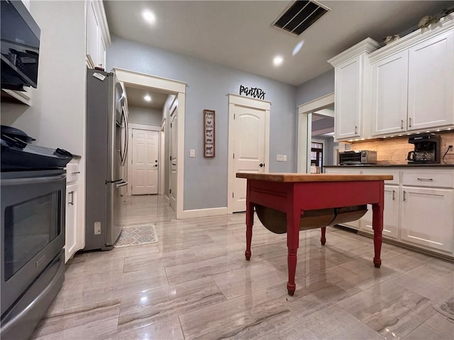 10059 Birdie St, Dardanelle, AR 72834 - kitchen with stainless steel appliances, white cabinetry, decorative backsplash, dark countertops, and recessed lighting