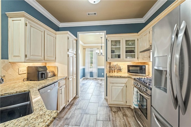 704 Weston Cir, Cave Springs, AR 72718 - kitchen with stainless steel appliances, a sink, ornamental molding, a chandelier, and light stone counters