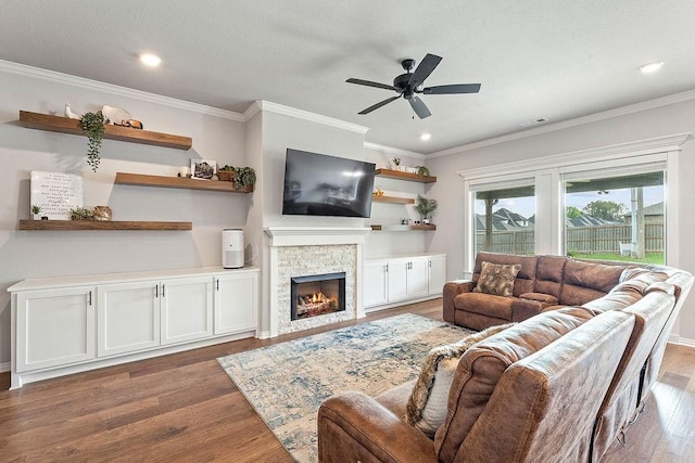 1904 Bergman Rd, Pea Ridge, AR 72751 - living area featuring wood finished floors, a ceiling fan, a stone fireplace, crown molding, and recessed lighting