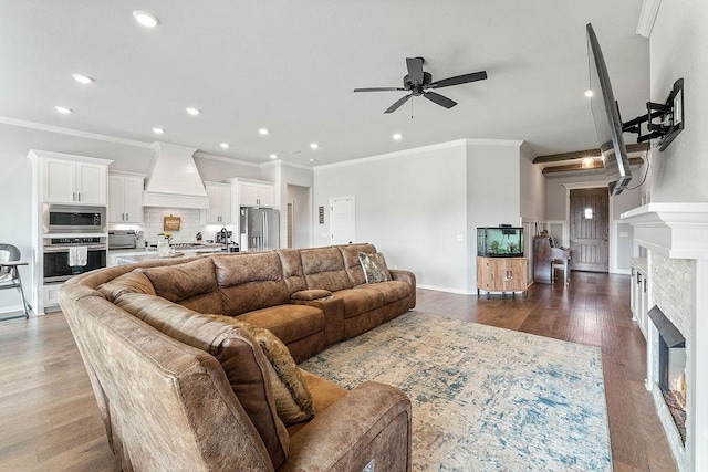 1904 Bergman Rd, Pea Ridge, AR 72751 - living room with a ceiling fan, ornamental molding, recessed lighting, a lit fireplace, and dark wood-type flooring