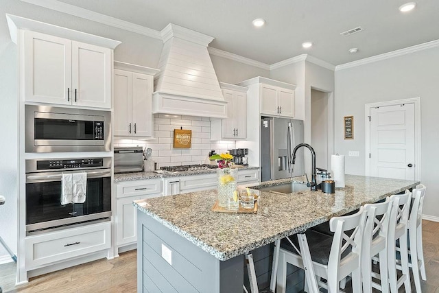 1904 Bergman Rd, Pea Ridge, AR 72751 - kitchen with stainless steel appliances, wall chimney range hood, ornamental molding, an island with sink, and a sink