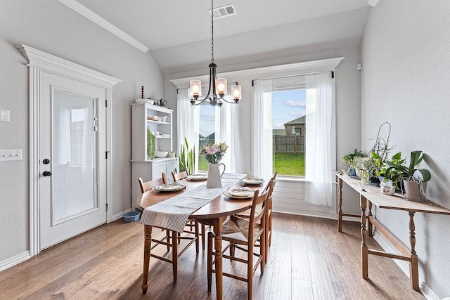 1904 Bergman Rd, Pea Ridge, AR 72751 - dining space with light wood-type flooring, a chandelier, baseboards, lofted ceiling, and crown molding
