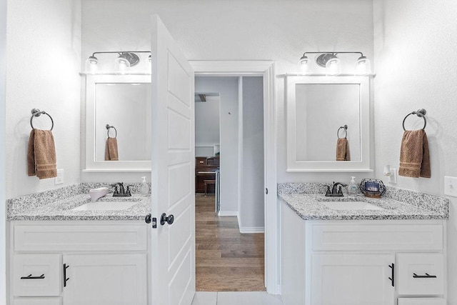 1904 Bergman Rd, Pea Ridge, AR 72751 - full bathroom with two vanities, wood finished floors, and baseboards