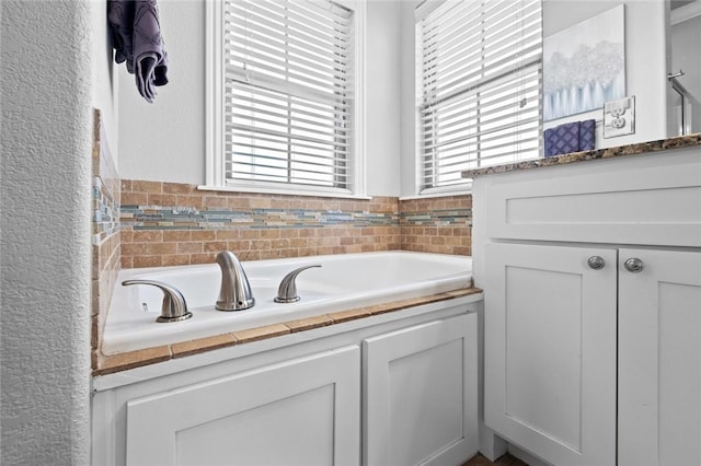 236 Ranalli Ave, Springdale, AR 72762 - bathroom featuring a garden tub, a textured wall, and vanity