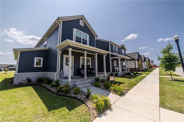 2009 Poppy St, Bentonville, AR 72713 - traditional-style house featuring a porch, brick siding, a front yard, and a residential view